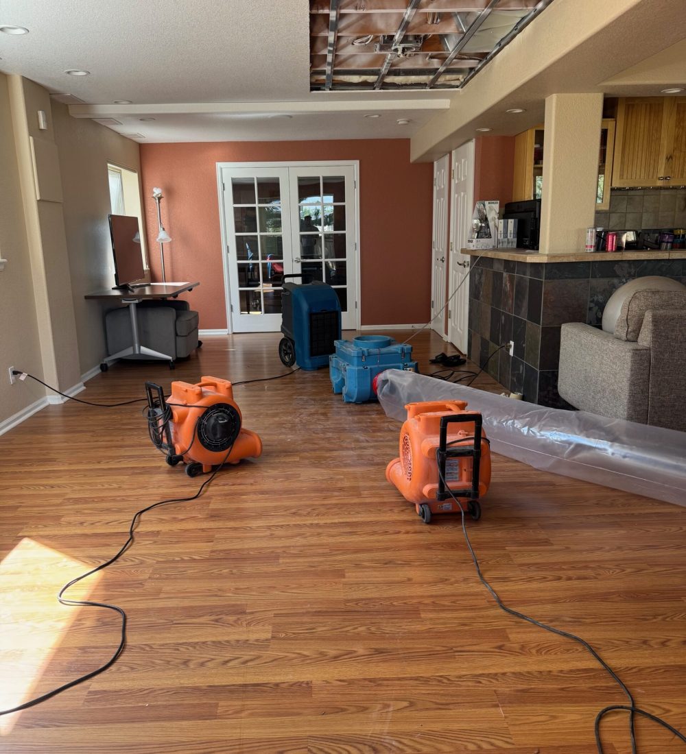 Air movers and drying equipment positioned in a home during structural drying and water damage restoration